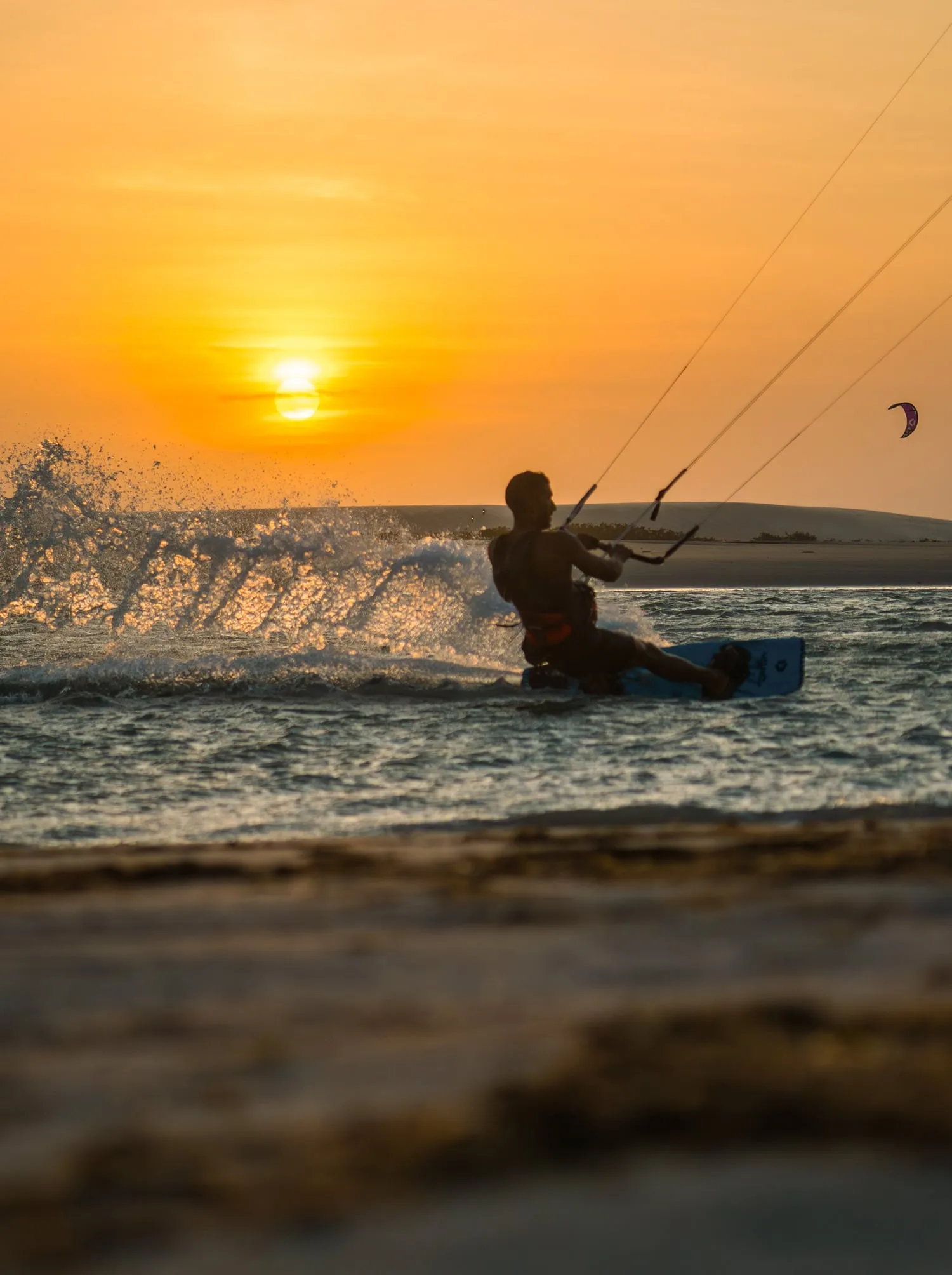 Kitesurfista velejando ao pôr do sol em Jericoacoara