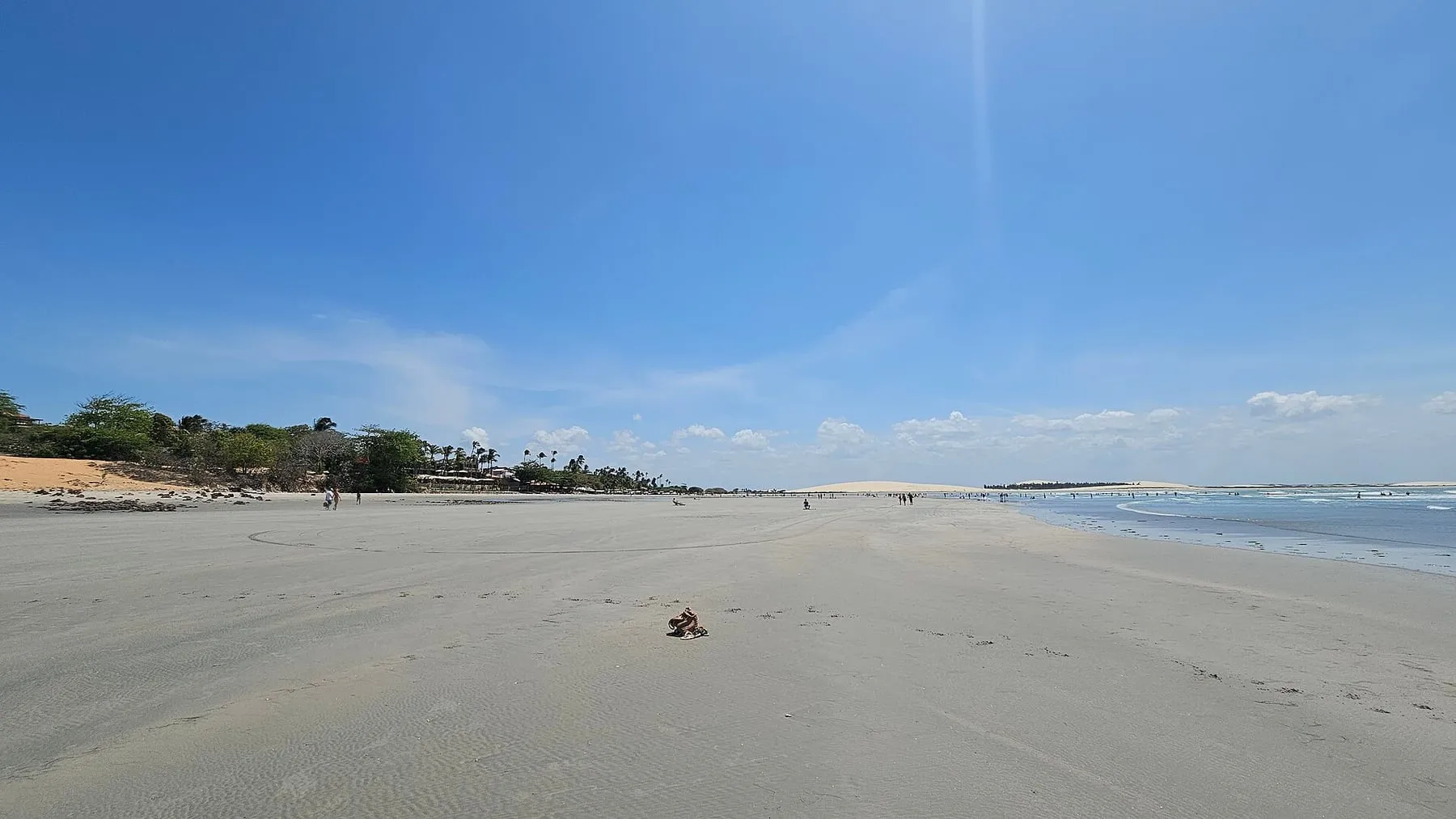 Breiter Sandstreifen des Jericoacoara-Strandes mit Dünen im Hintergrund